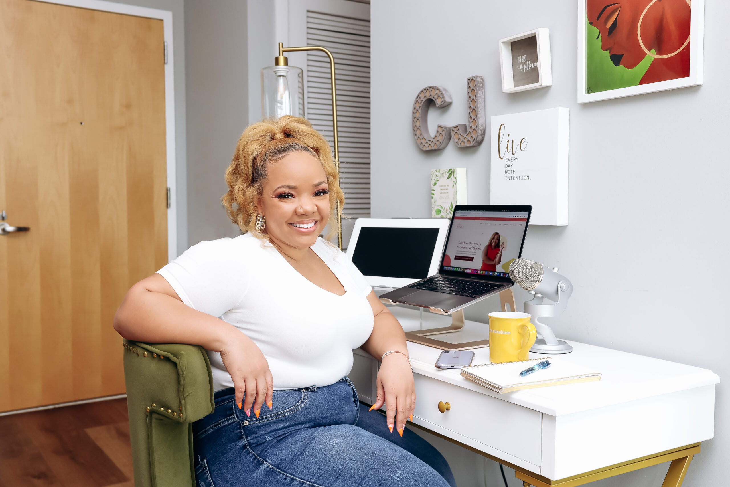 Black woman with blonde hair sitting in front of a desk workspace
